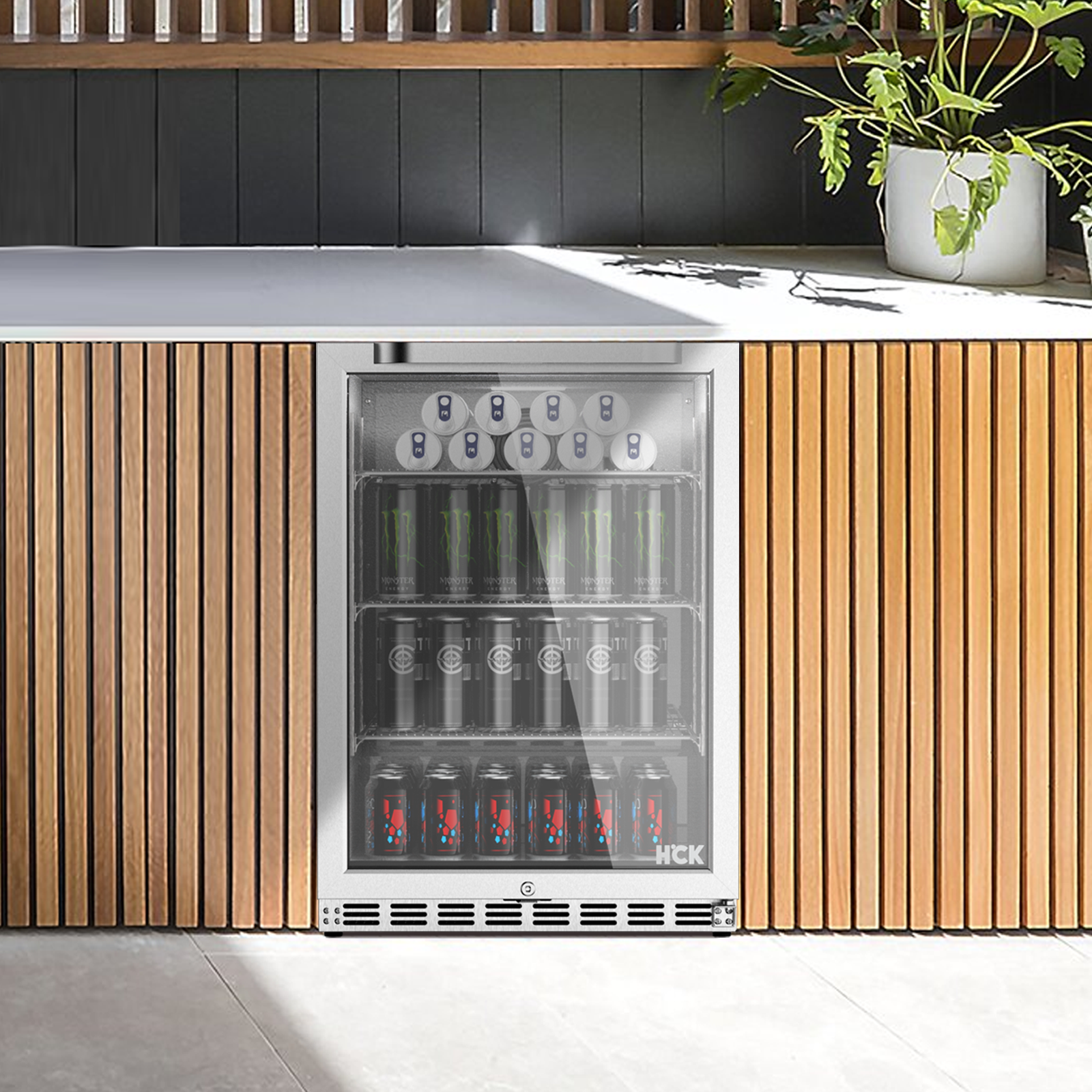 A front view of the outdoor setup with the 5.12 Cu Ft Beverage Outdoor Refrigerator 132 cans installed in a suitable place. A flower pot is positioned above the fridge