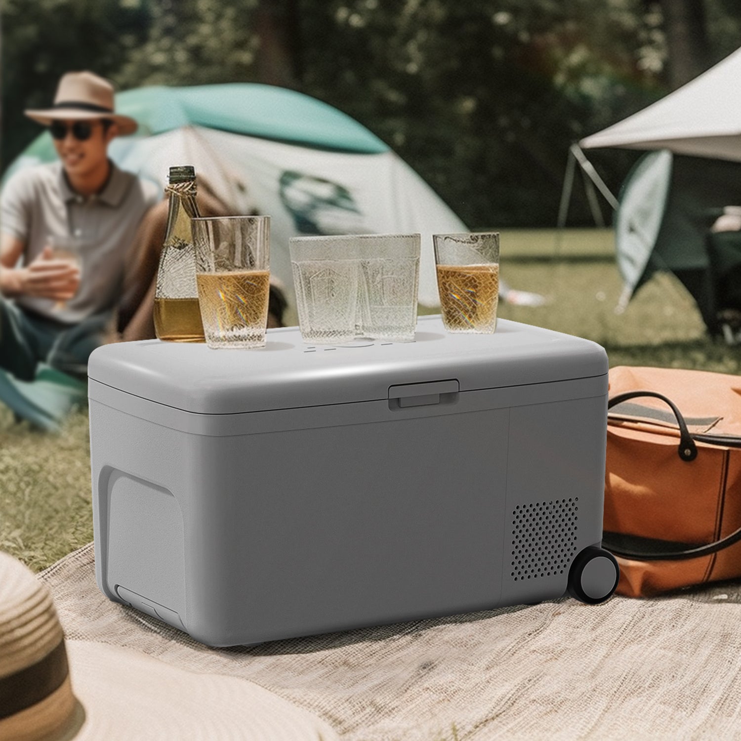 Side view of a 0.6 Cu ft Camping Outdoor Refrigerator in a camping setting, with glasses placed on top.