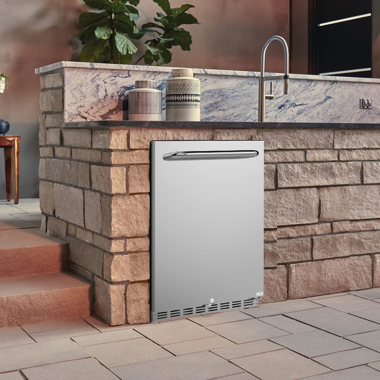 Side view of an outdoor setting with a 5.12 Cu Ft Undercounter Beverage Outdoor Refrigerator 161 Cans installed in a suitable position against a brick surface